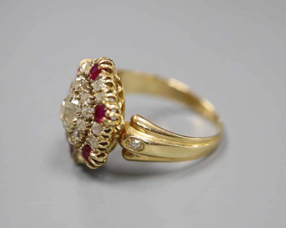 A Victorian style yellow metal ruby and diamond oval cluster ring, with central rectangular cushion cut stone, size L, gross